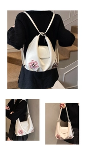 Detail showing the white PU leather bag with flower embroidery and versatile straps