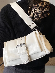 White minimalist baguette bag with wide strap and large silver buckle for daily commute