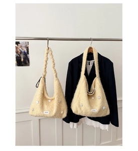 Dettaglio di borse tote in peluche beige con ciondoli a stella e manici morbidi arricciati