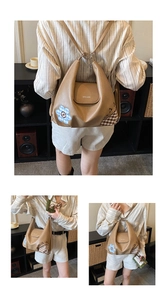 Detail view of khaki PU leather backpack with daisy patch and brown plaid side stitching