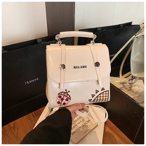 Detail of cream multi-functional bag with HELAHE logo and cute beetle decoration