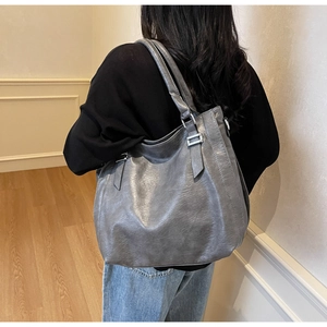 Macro detail of a large grey soft leather tote bag with silver hardware and shoulder straps