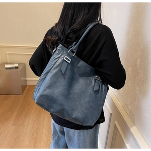 Detail of blue leather tote bag showing spacious interior and silver metallic buckle