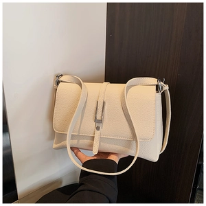 Detailed macro view of the cream-colored lychee pattern leather and silver metal buckle