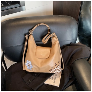 Detail of camel PU leather shoulder bag with floral patchwork and HELAHE logo on flap