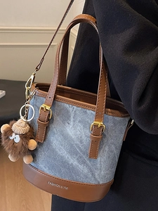 Blue denim bucket bag with brown leather trim and cute monster plush pendant