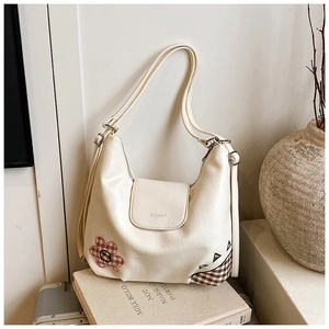 Detail of off-white Hobo bag with artistic patchwork, logo embossing and adjustable strap