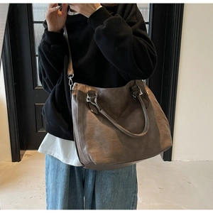 Detail of dark brown vintage leather tote bag showing textured finish and silver hardware