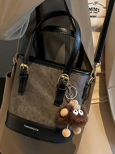 Retro bucket handbag in dark gray leather with plush doll pendant and adjustable strap