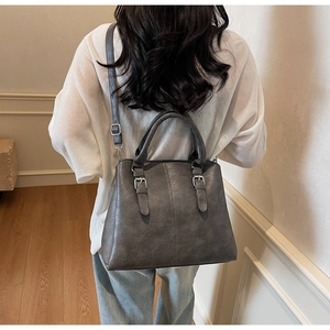 Vue détaillée du sac à bandoulière gris vintage avec sangle réglable sur un modèle de dos