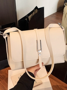 Minimalist beige grainy leather crossbody bag with silver metal buckle and wide shoulder strap