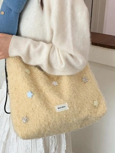 Borsa tote in pile con toppe a stella ed etichetta Beyou Merci, indossata da una modella