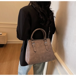 Vue détaillée du sac à main taupe avec boucle métallique argentée et grain litchi