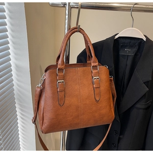 Vue détaillée du sac cabas en cuir marron avec doubles poignées et bandoulière réglable