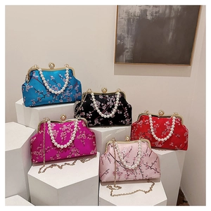 Detail of silk clutch bags with cherry blossom embroidery and pearl clasp accents