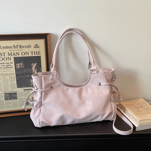 Detail view of large pale pink tote bag with drawstring texture and side pocket
