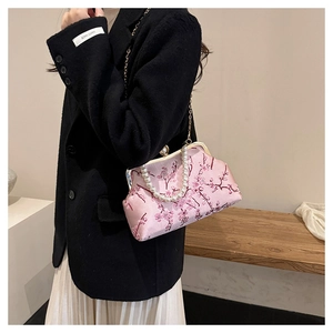 Detail of pink satin bag with cherry blossom embroidery and premium pearl handle