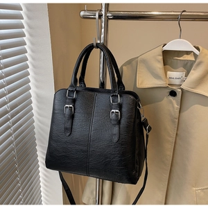 Détail du sac cabas en cuir PU noir texturé avec boucle argentée et bandoulière réglable