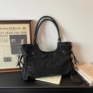 Detail view of large black matte suede tote bag with drawstring and metal eyelets
