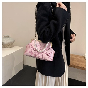 Close-up of pink satin evening bag with cherry blossom embroidery and pearl handle