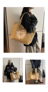 Detail showing white daisy embroidery and letter pattern on khaki canvas tote bag