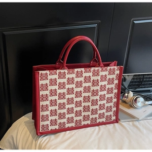 Détail du sac cabas de mariage rouge avec motif traditionnel dans un décor moderne