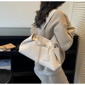 Detail of cream white glossy leather tote bag with silver buckle and shoulder strap