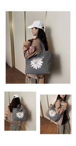 Detail of dark grey canvas tote bag with white daisy embroidery and Maodo lettering