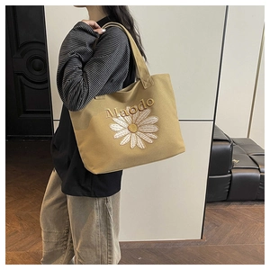 Detail of embroidered daisy and Maodo lettering on khaki canvas tote bag
