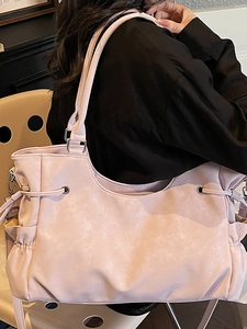Pink faux leather large tote bag with drawstring detail shown on female model