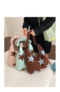 Detail view of corduroy tote bags with plush star patches and ruched elastic handles