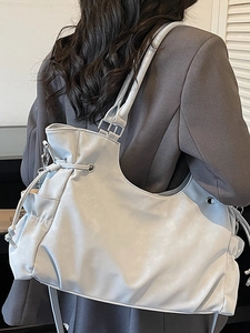 Vintage large capacity silver tote bag worn by a model in a charcoal grey suit for office style
