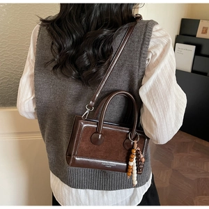 Detail of dark brown leather crossbody bag with wooden beads on model back