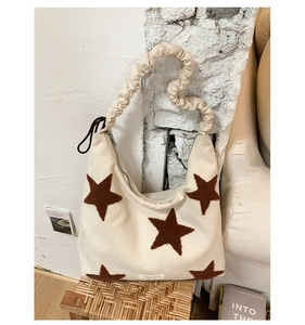 Detailed texture of canvas tote with plush brown star and pleated cloud shoulder strap