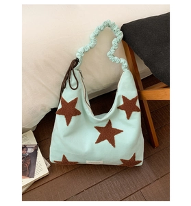 Close-up of mint green plush star shoulder bag with drawstring detail and ruffled strap