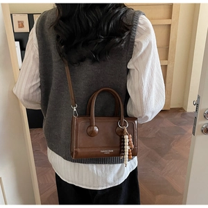 Model view showing the vintage brown crossbody bag size and fit in a cozy indoor setting