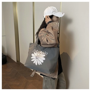 Vue détaillée du sac cabas en toile grise avec broderie de marguerite et grande capacité