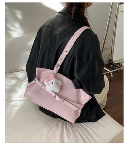 Detail of pink faux leather tote bag with stylish buckle and cute white kitten charm