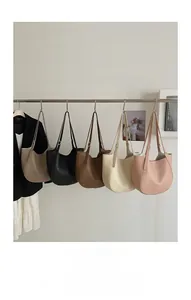 Five minimalist pebbled leather tote bags in various colors on a display rack