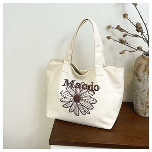 Détail de la broderie fleurie marguerite et texte Maodo sur le sac cabas en toile