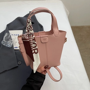 Close-up of pink bucket bag featuring fashion texture and stylish silk scarf on the handle