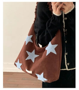 Detail of plush star pattern and ruched strap on a brown suede shoulder bag for women