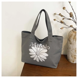 Détail du sac cabas en toile gris foncé avec broderie marguerite et sangle renforcée