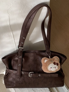 Deep brown matte leather tote bag with silver eyelets and a cute bear charm pendant