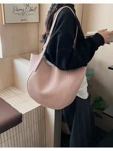 Close-up of pink lychee textured leather and adjustable strap on the hobo shoulder bag