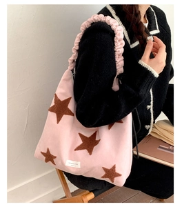 Close-up of pink plush star tote bag with brown felt stars and ruffled shoulder strap