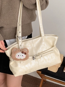 Chic cream white glossy tote bag with buckle detail and plush bear charm for women