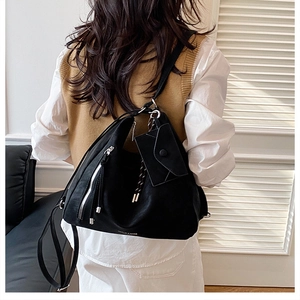 Macro detail of large black leather hobo bag with silver hardware and small coin purse attachment