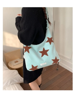 Detail of mint green plush shoulder bag with brown star patterns and ruched strap