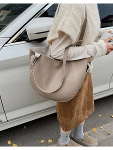 Detail of soft pebbled leather texture and adjustable strap on large tote bag